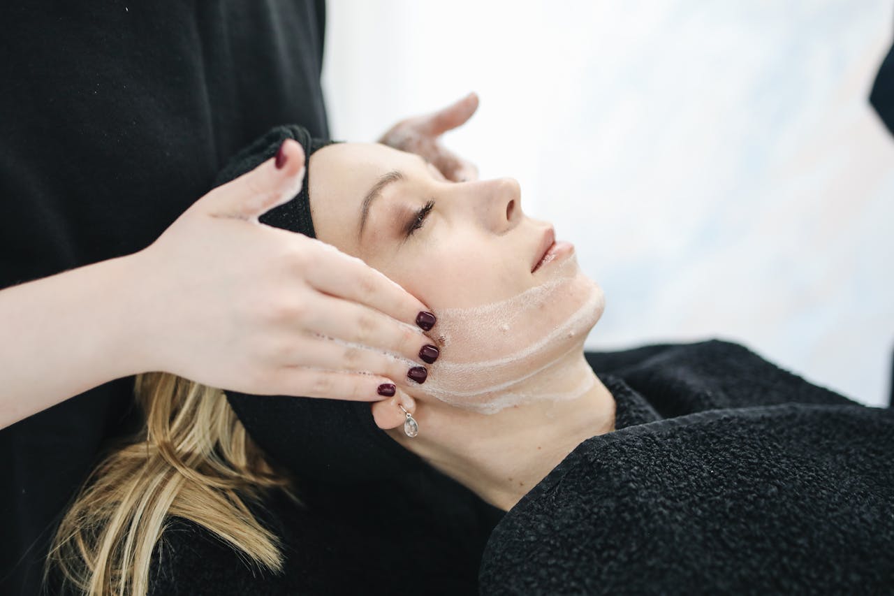portfolio-04 Side view of a woman receiving a soothing facial treatment at a spa, promoting wellness and skincare.