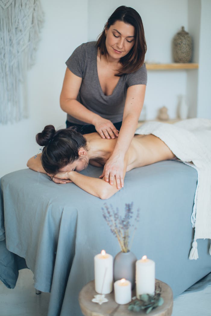 portfolio-05 A serene spa setting with a therapist giving a back massage to a female client for relaxation.